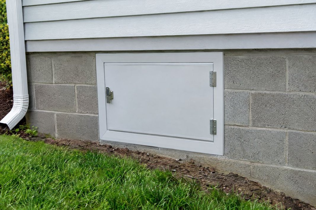 Airtight insulated crawl space access door sealed into the foundation wall